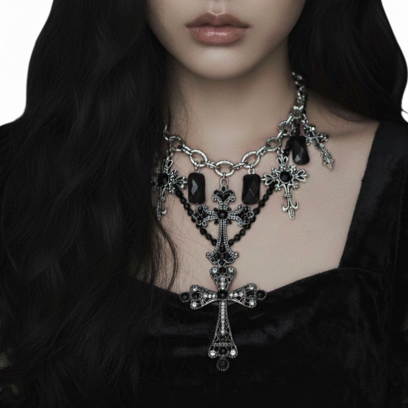 Close-up of a person wearing an ornate necklace with crosses and black stones on a plain background