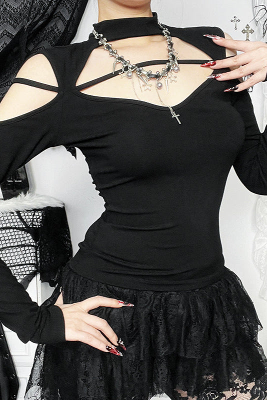 Person wearing a black long-sleeve top with cut-out design and a black lace skirt.