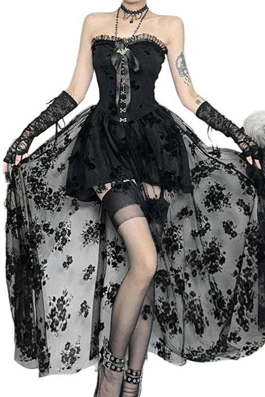 Person wearing a black lace dress with sheer overlay in a decorative setting.