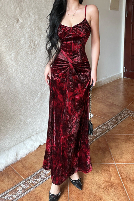 Woman wearing a red velvet dress standing on a tiled floor.