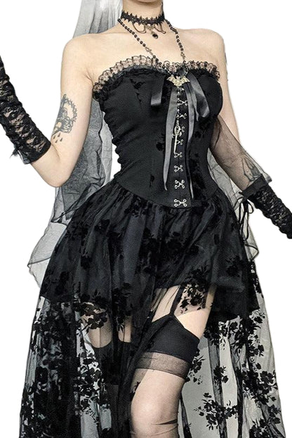 Person wearing a black lace dress with floral details in a gothic setting.