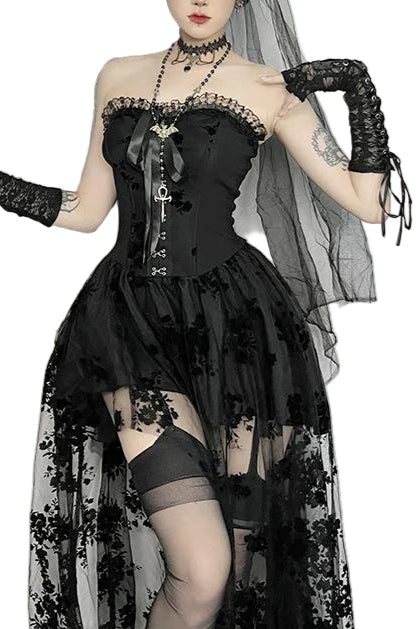 Person wearing a black lace dress with sheer sleeves and stockings, standing against a white curtain.