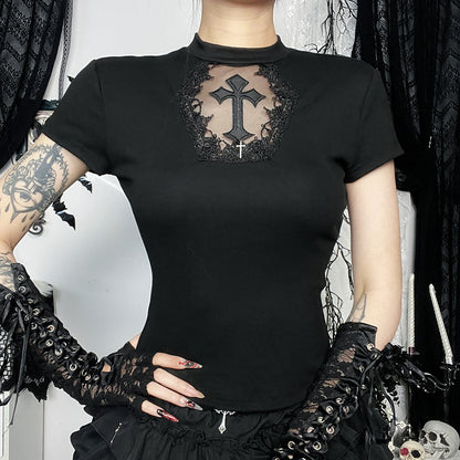 Person wearing a black t-shirt with a cross design, black gloves, and a black skirt in a gothic setting.