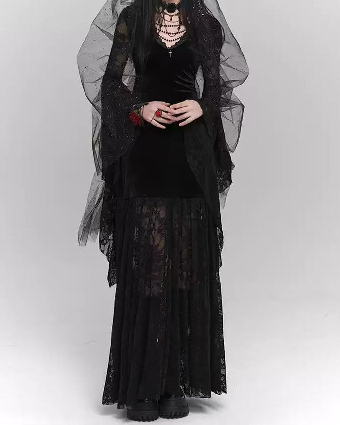 Person wearing a black gothic outfit with a sheer black veil on a white background