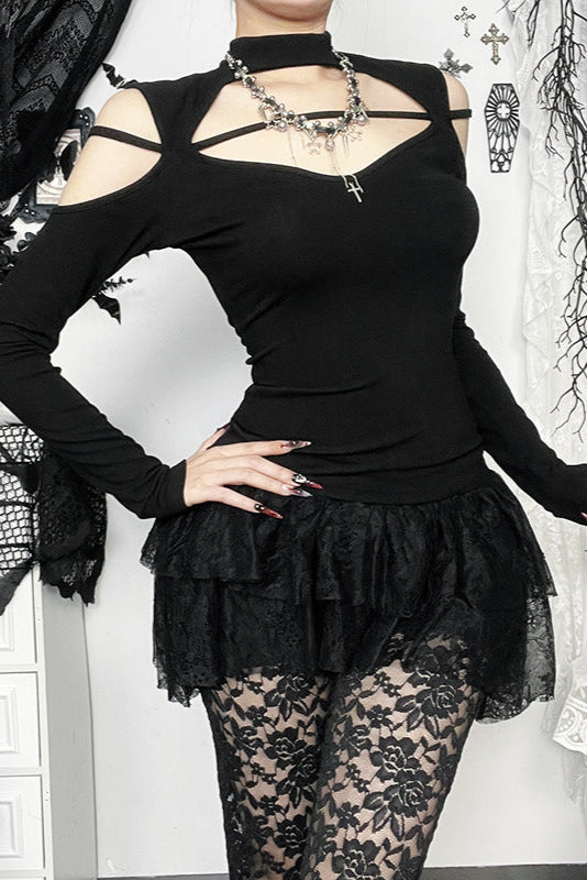Person wearing a black outfit with lace details and a necklace.