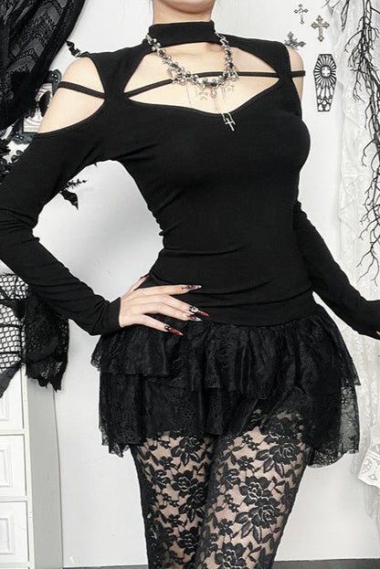 Person wearing a black outfit with lace details and a necklace.