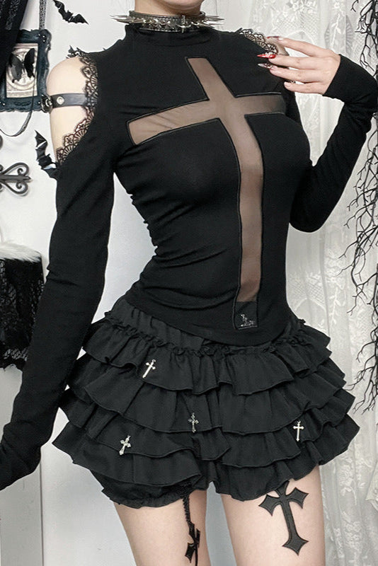 Person wearing a black outfit with sheer panels and ruffled skirt in a gothic-style setting.