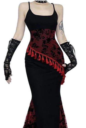 Person wearing a black and red floral dress with gloves in a room setting.