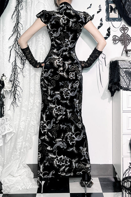 Person wearing a black floral dress in a decoratively styled room with white curtains and black and white checkered floor.