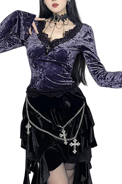 Person wearing a dark, gothic-style outfit with long sleeves and decorative chains.