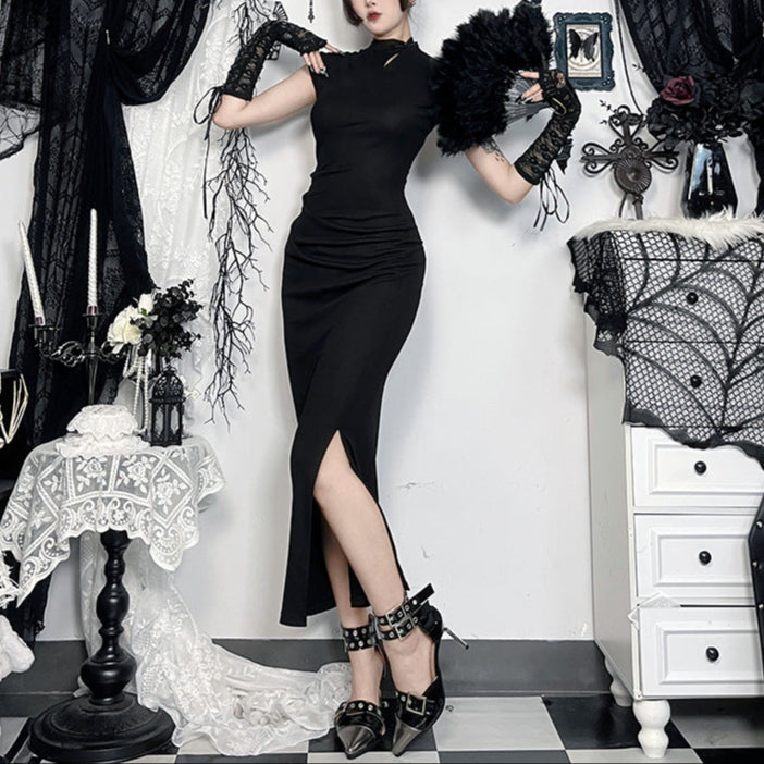 Woman in a black dress and gloves posing in a gothic-style room with black and white decor.