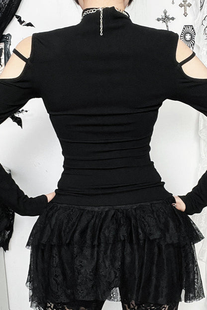 Black outfit with ruffled skirt and cut-out shoulders against a decorative background