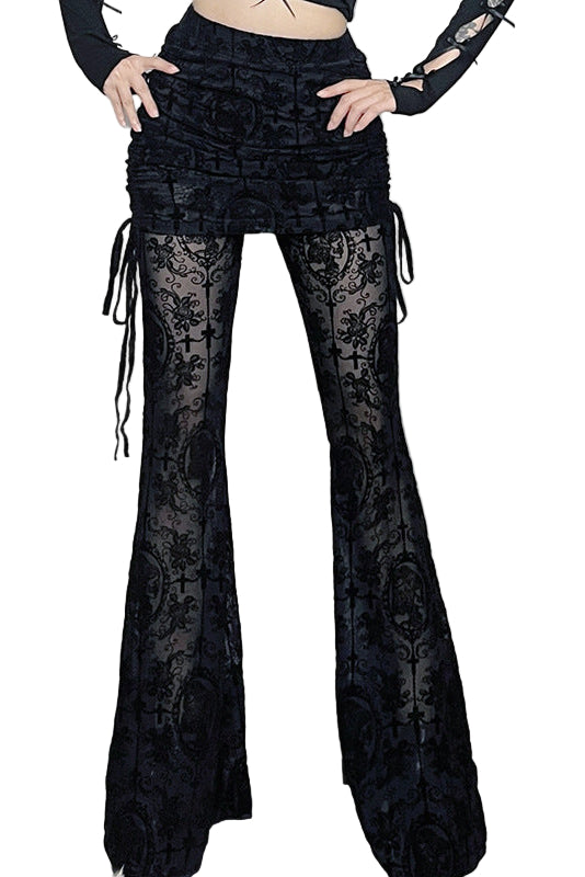 Person wearing black lace bell-bottom pants in a decorative room with skulls and flowers.