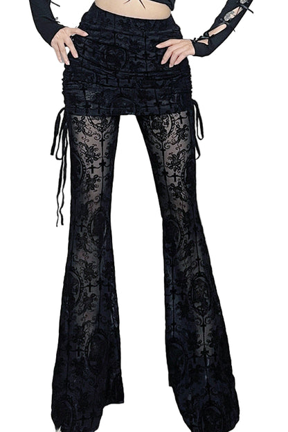 Person wearing black lace bell-bottom pants in a decorative room with skulls and flowers.