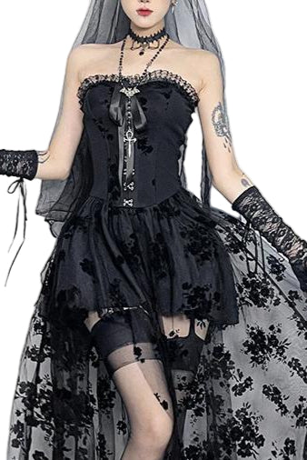 Person wearing a black gothic dress with floral details in a decorative setting.