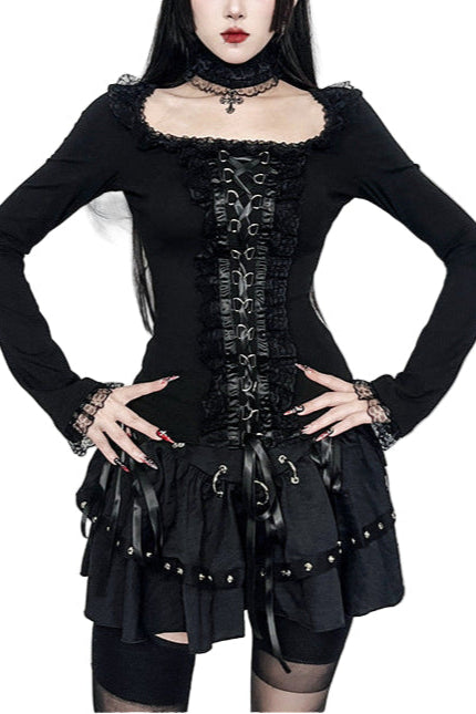 Person wearing a black gothic outfit with decorative elements in a styled setting.