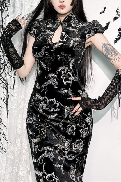 Woman wearing a black floral dress with lace sleeves in a decorative setting.