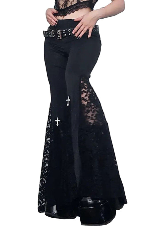 Person wearing black lace pants with a white door background