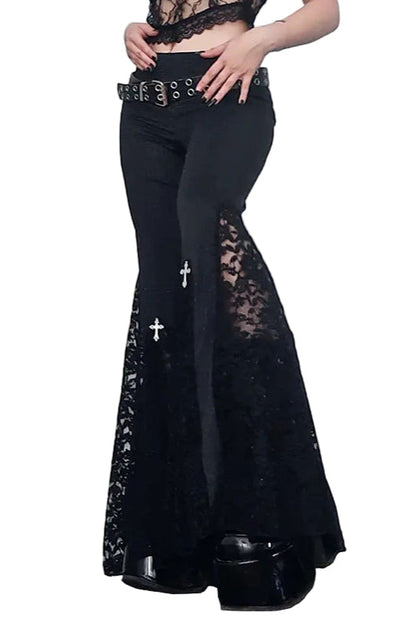Person wearing black lace pants with a white door background