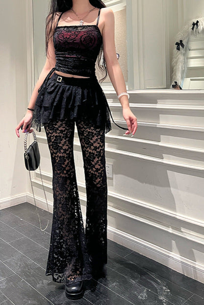 Person wearing a black lace outfit in a room with white walls and gray floor.