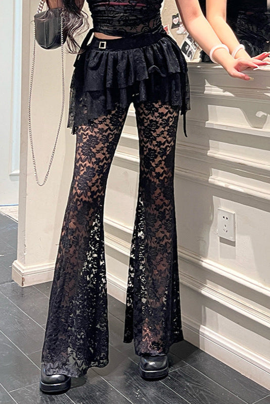 Person wearing black lace pants in a room with gray flooring and white walls.