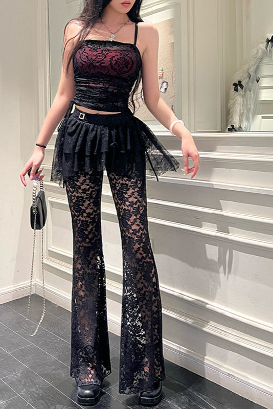 Person wearing a black lace outfit standing in a room with a mirror.