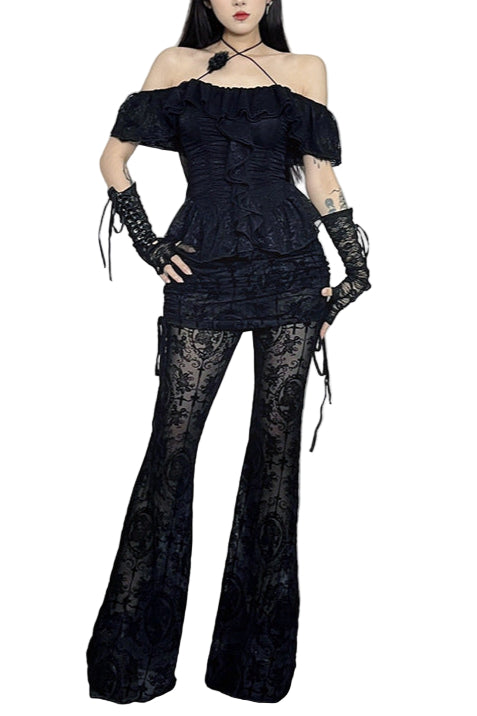 Woman in a black outfit standing in a Halloween-themed room with decorations.