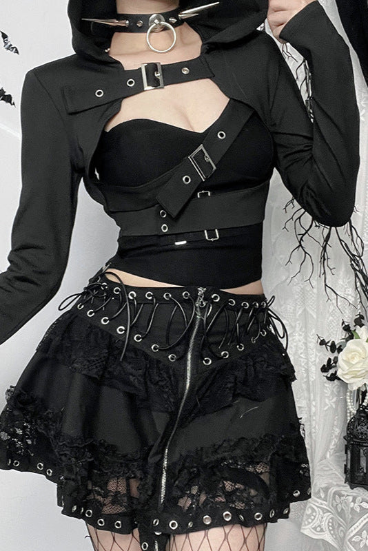 Person wearing a black gothic outfit with lace details against a decorative background.