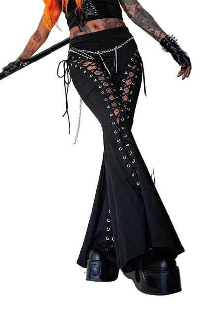 Person wearing black lace-up pants and platform shoes on a staircase.