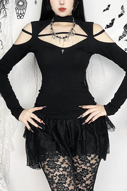 Woman in a black outfit with lace details in a gothic-style room.