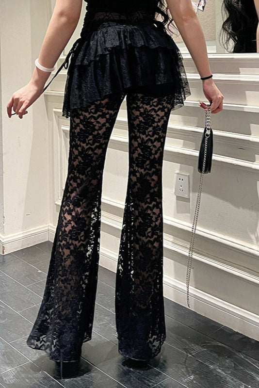 Person wearing black lace pants in a room with stairs.