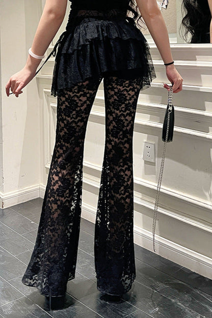 Person wearing black lace pants in a room with stairs.