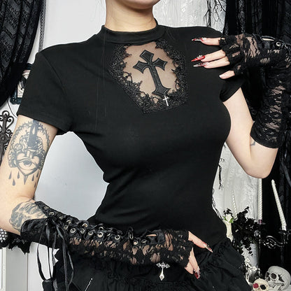 Person wearing a black top with lace and cross design, standing against a dark background.