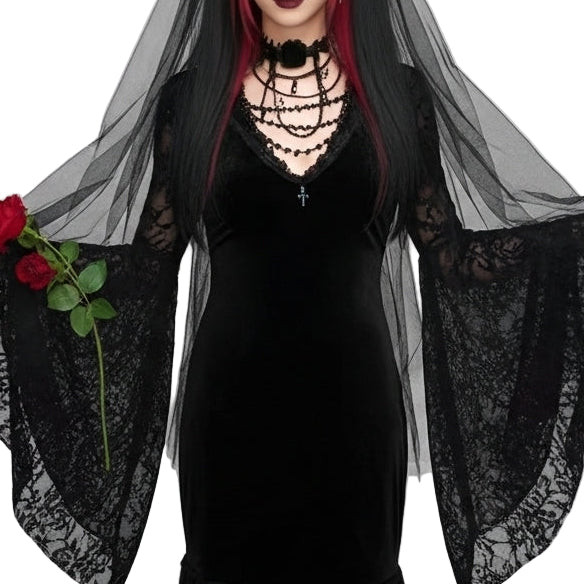 Person wearing a black dress with a sheer black shawl and red hair, holding roses against a light gray background.